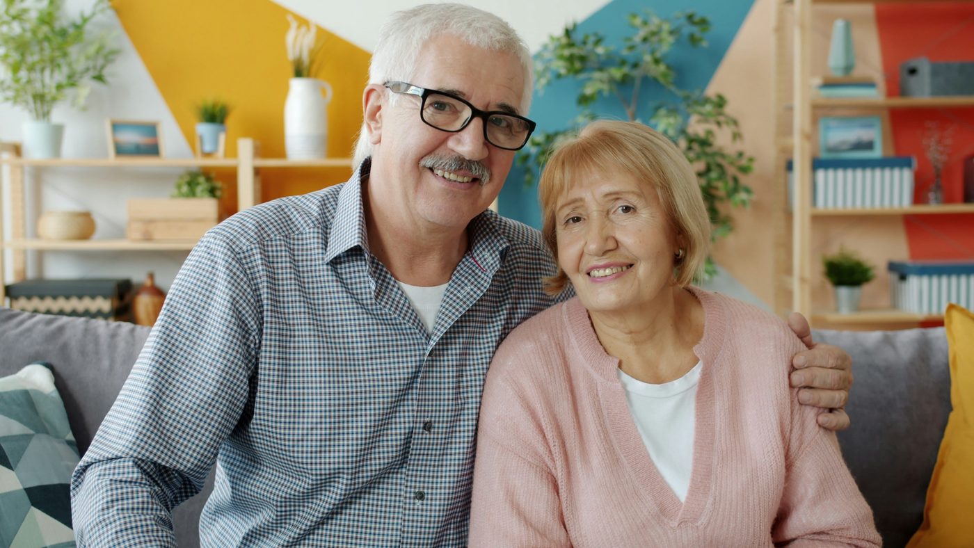 An older couple sitting together on a sofa at home